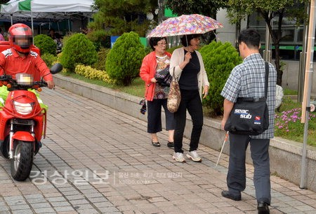 점자블록이 없어 위험하게 걷고 있는 시각장애인 사진